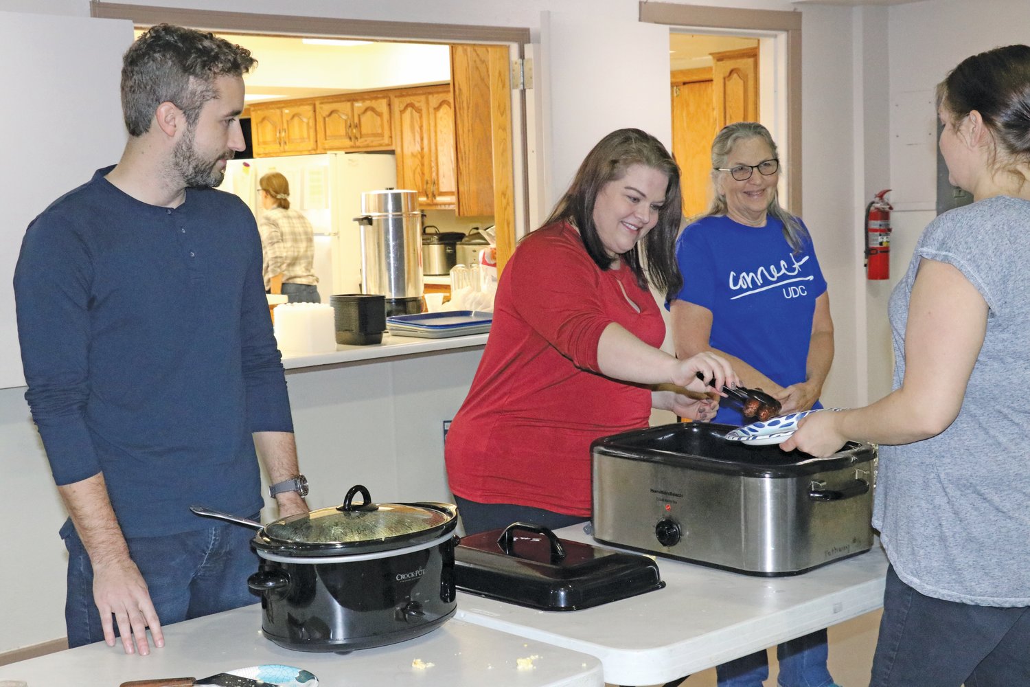 Hannah Bontrager, middle, and Randall Gingerich, left, serve up fried mush, pancakes, sausages, eggs and fruit during a fundraiser for Freedom 423 on Saturday, Dec. 4 at Pathway Christian School.